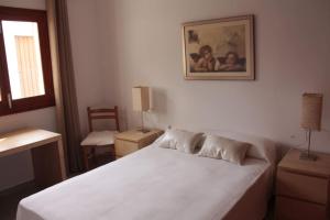 a bedroom with a white bed and a picture on the wall at Bonito Chalet en Sa Ràpita in Sa Ràpita