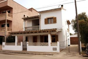 una casa blanca con una valla delante en Bonito Chalet en Sa Ràpita en Sa Ràpita