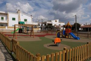 un parque infantil con zona de juegos con tobogán y columpios en Bonito Chalet en Sa Ràpita en Sa Ràpita
