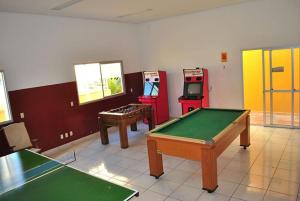a room with two arcade games and a pool table at Thermas Place in Caldas Novas