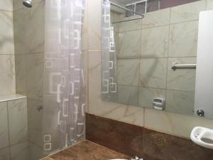 een badkamer met een douche en een spiegel bij Bungalows Cerro Azul in Cerro Azul +103 foto's