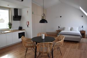 una habitación con una mesa y sillas y una cama en Venezapartments, en Aveiro