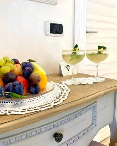 a bowl of fruit on a table with two drinks at La Vista del Poggio in Castellaro