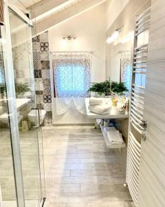 a bathroom with a glass shower and a sink at La Vista del Poggio in Castellaro