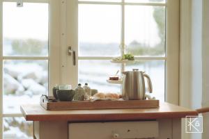 um balcão de cozinha com uma chaleira e uma janela em Kardemommehuset em Vester-Skerninge