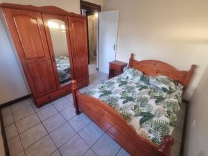 a bedroom with a wooden bed and a mirror at Féfé in Vieux-Habitants