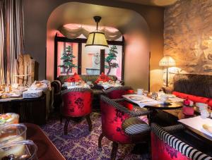 a restaurant with red chairs and tables and a mirror at Hotel Odeon Saint-Germain in Paris