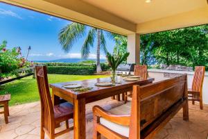 a dining room with a table and chairs on a patio at Makena Aloha Estate in Lahaina