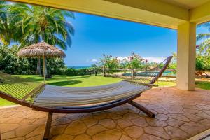 a hammock on a patio with a view of the ocean at Makena Aloha Estate in Lahaina