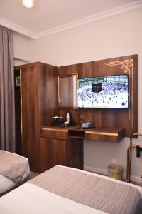 a hotel room with a bed and a flat screen tv at Dar Al Naem Hotel in Al Madinah