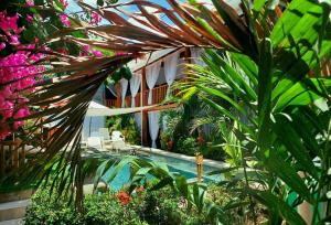 a swimming pool in a garden with plants and flowers at BellaVista Suites By Villas Verdes - Samara Beach in Sámara