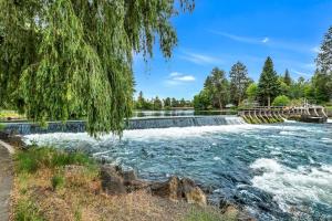 a river in a park with a waterfall at Bend Riverside Condos Near Downtown Bend in Bend