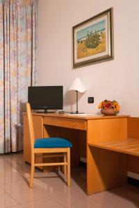 Camera dotata di scrivania con computer e sedia. di Hotel Astoria ad Alberobello