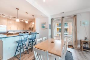 cocina y comedor con mesa de madera y sillas en The Sanctuary - No Worries 304B en Virginia Beach