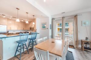 a kitchen and dining room with a wooden table and chairs at The Sanctuary - No Worries 304B in Virginia Beach
