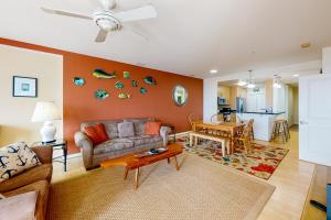 una sala de estar con un sofá y una mesa en The Sanctuary - Roaring Sunset 230B, en Virginia Beach