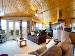 a living room with a couch and a table at 3 Bedroom Lakeview Lodge - Ensuite & Balcony Deck in Carnforth