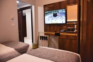 a room with two beds and a flat screen tv at Dar Al Naem Hotel in Medina