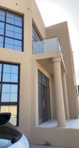 a house with a balcony with a staircase on it at Al Ghadeer Maison Masfout in Sharīyah