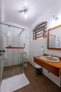 a bathroom with a glass shower and a sink at Pousada do Sitio in São Bento do Sapucaí