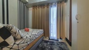 ein kleines Schlafzimmer mit einem Bett und einem Fenster in der Unterkunft EZBeds Mall of Asia in Manila