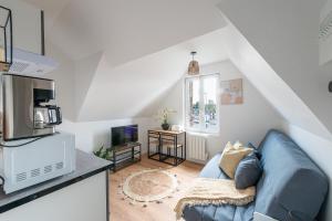 a living room with a blue couch and a kitchen at Résidence Kyjay in Cambrai