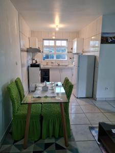 uma cozinha com uma mesa e cadeiras e um frigorífico em CHEZ VERVEINE em Saint-Laurent du Maroni