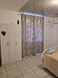 um quarto com uma cama e uma cortina de chuveiro em CHEZ VERVEINE em Saint-Laurent du Maroni