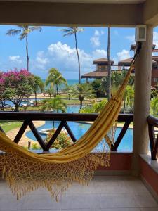 a hammock on a balcony with a view of the ocean at Beach front apartment in Dream Village Cumbuco, Ceara in Cumbuco