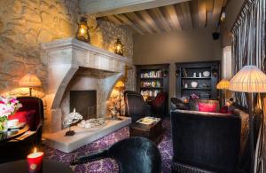 パリにあるホテル　オデオン　サンジェルマンの石壁のリビングルーム(暖炉付)