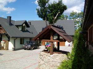 a house with a tree in a stone fountain at Stara Kuźnia in Sosnówka