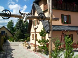 a wooden cross with a cow head on it in front of a building at Stara Kuźnia in Sosnówka