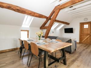 een eetkamer met een houten tafel en stoelen bij Lower Venn Granary Apartment 2 in Wellington