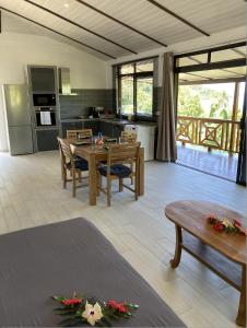 FARE ARIITEA في بورا بورا: مطبخ وغرفة معيشة مع طاولة وكراسي