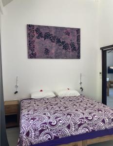1 dormitorio con 1 cama con una foto en la pared en FARE ARIITEA, en Bora Bora