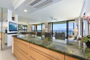 a kitchen with a large island in a living room at Papakea F-310 in Lahaina