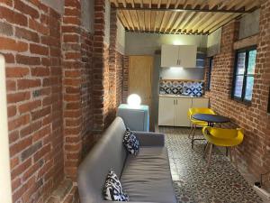 a living room with a couch and a brick wall at Mina 32 - Coyoacan in Mexico City