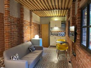 a living room with a couch and a table and a kitchen at Mina 32 - Coyoacan in Mexico City