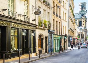 a city street with buildings and a traffic light at Hotel Odeon Saint-Germain in Paris