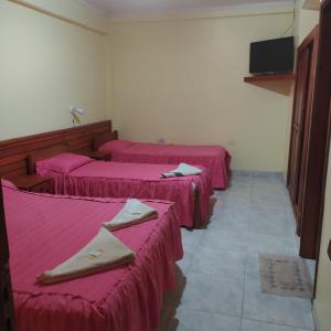 プエルトイグアスにあるLos riosのピンクのシーツが敷かれたベッド3台が備わる部屋 +11枚の写真