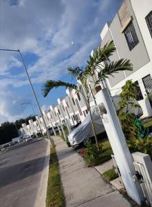 un trottoir avec des palmiers à côté d'une rue dans l'établissement Casa Vacacional Balam - en Cancún, à Cancún