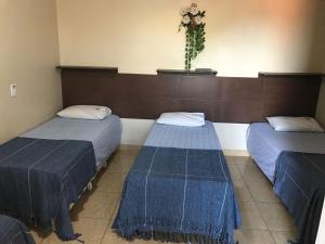 a room with two beds with blue covers on them at Recanto do Carreiro in Trindade