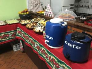 una mesa con un buffet de comida y postres en Recanto do Carreiro en Trindade
