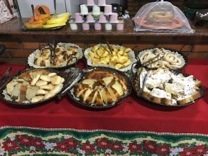 a table topped with trays of different types of food at Recanto do Carreiro in Trindade +7 photos