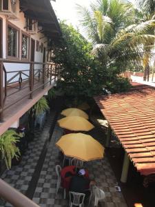 a group of people sitting under umbrellas on a patio at Recanto do Carreiro in Trindade