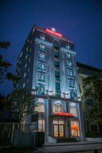 ein Hotelgebäude mit einem beleuchteten Schild darauf in der Unterkunft Sunrise Hải Tiến in Thanh Hóa