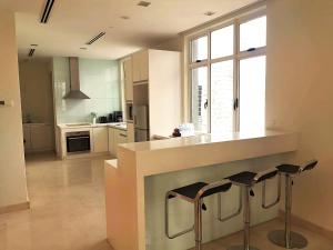 a kitchen with a counter and two bar stools at Cormar Suites in Kuala Lumpur