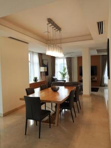a dining room and living room with a table and chairs at Cormar Suites in Kuala Lumpur