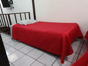 ein Bett mit einer roten Decke auf einem Zimmer in der Unterkunft Pinares de Tecla in Nueva San Salvador
