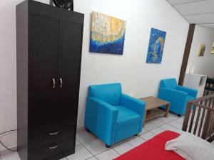 a bedroom with a blue chair and a cabinet at Pinares de Santa monica 6HB in Nueva San Salvador